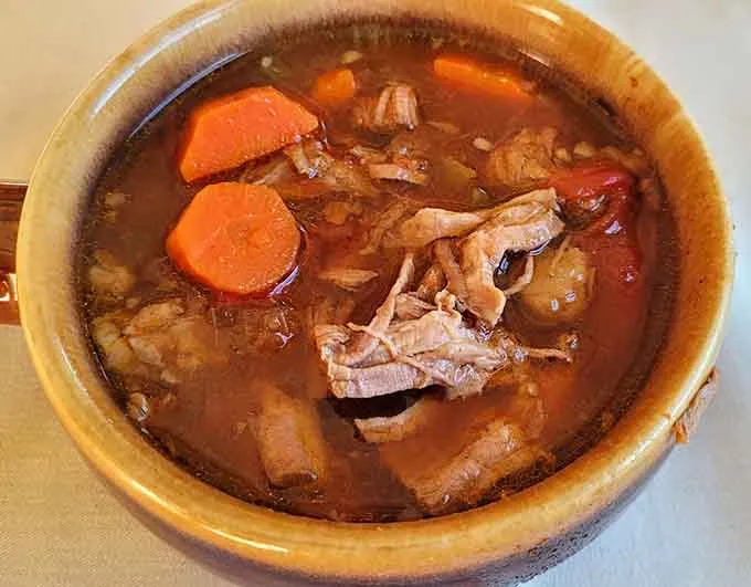 Beef and vegetable soup in a stoneware crock