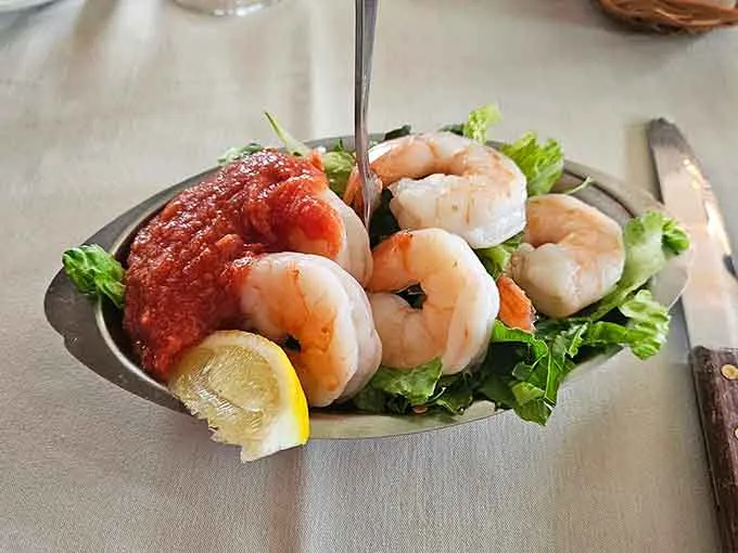 Shrimp cocktail on greens with lemon wedges